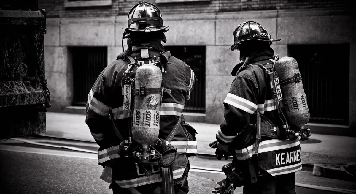 Deux pompiers en pleine tenue de pompier, de dos